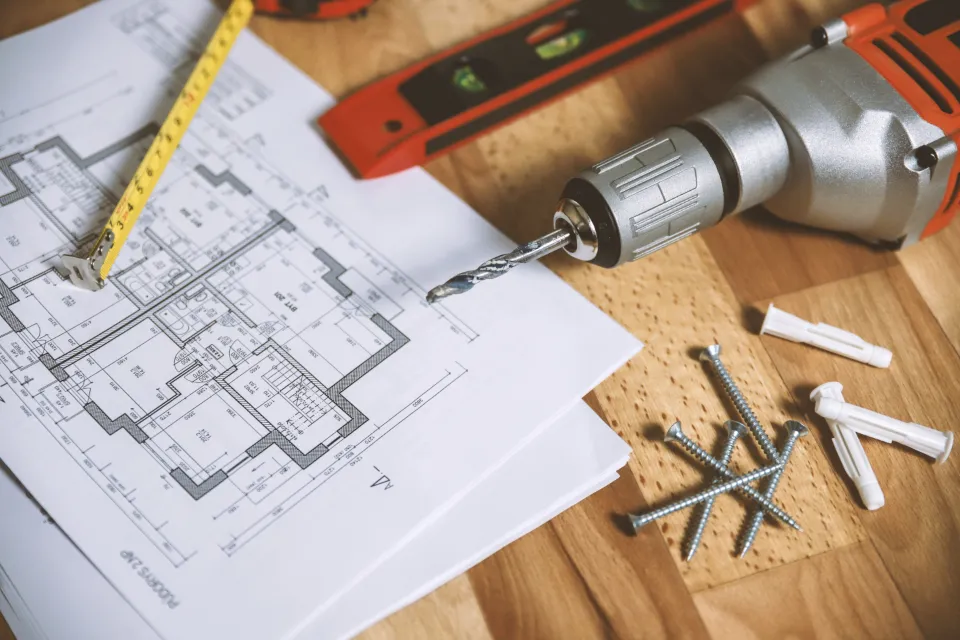 Plan de travaux et outillage posés sur un établi