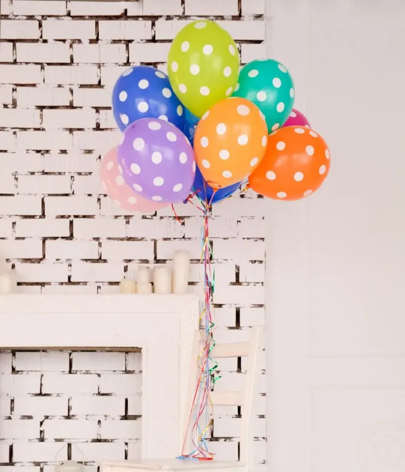 Ballons colorés contre un mur blanc